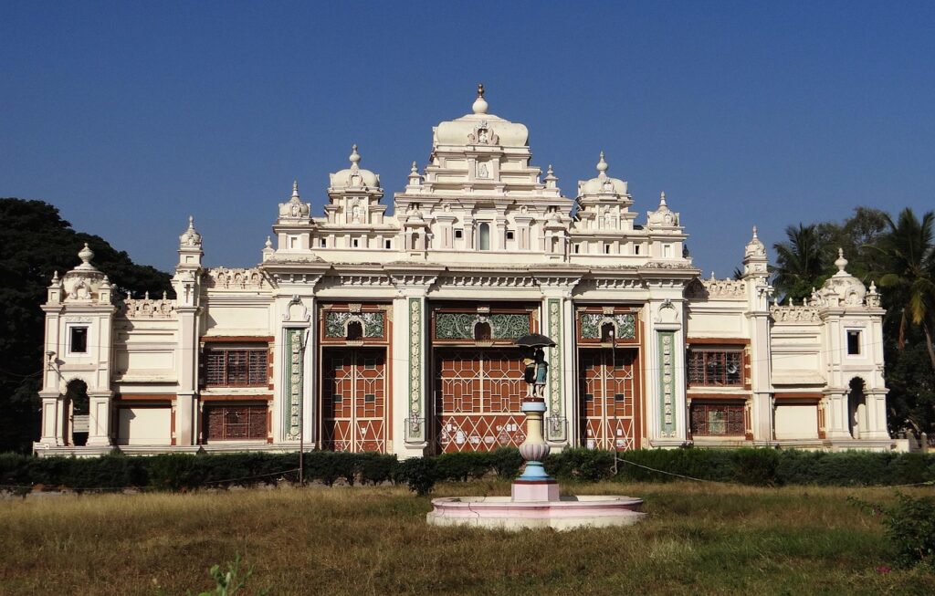 An landscape showing a  white color palace with water fountain and blue sky