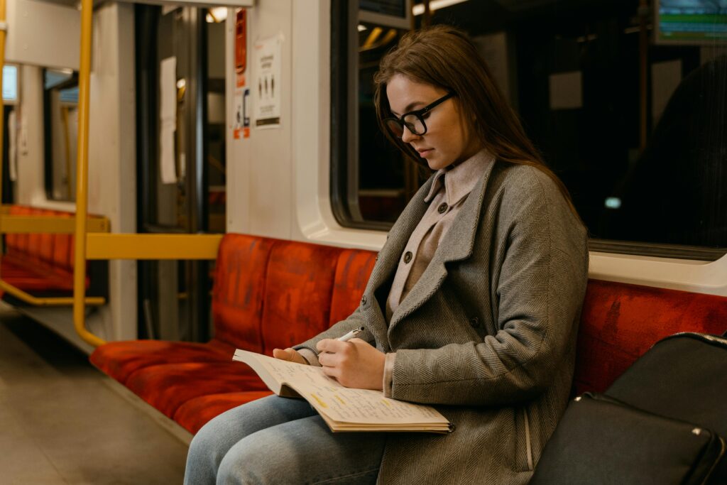A landscape showing that a girl traveling in train and writing in a book