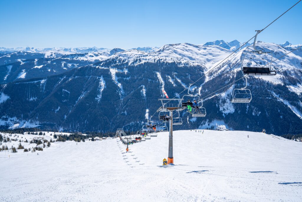 The ropeway with the snow-covered Alps in the background under a blue clear sky